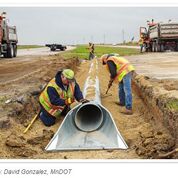 Workers Working on a Partially Buried Pipe